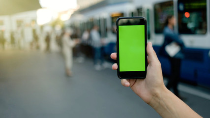 Man hands holding smart phone with green screen .