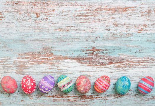 Colorful Easter egg side border against a rustic wood Vintage pastel background