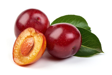 Ripe sweet red plums with leaves and a half of red plum fruit with core, isolated on white...