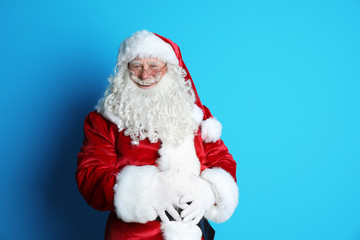Fototapeta na wymiar Portrait of authentic Santa Claus on color background