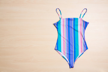 Beautiful swimsuit on wooden background, top view