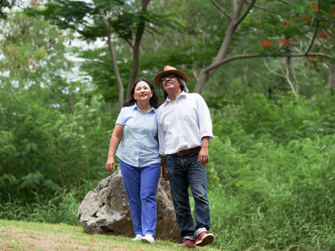 Senior couple walking together in summer park,travel together concept.