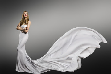 Fototapeta premium Woman White Dress, Fashion Model in Long Silk Sexy Gown, Waving Tail Flying Fabric Train, Cloth Fluttering on Wind