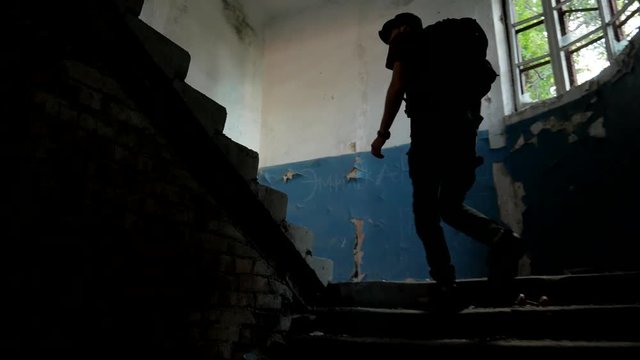 Traveler walks up at stairs of abandoned old building