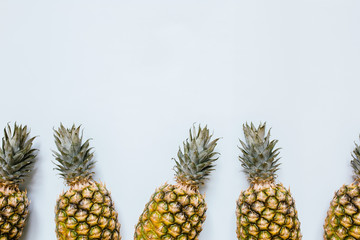 Ripe pineapples border frame on white background isolated. Empty space for text, copy, lettering. Minimalist trendy style concept.