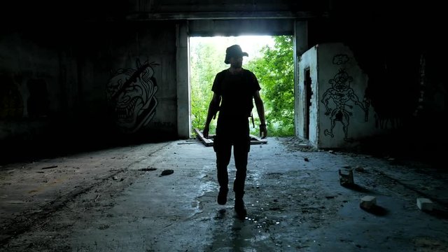 Stalker enter to the dark abandoned garage during wasteland exploring