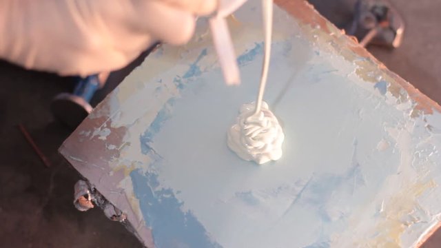 Auto body, body filler being mixed on a, in order to fill a dent on on a truck. This light blue polyester filler is also known as Bondo.