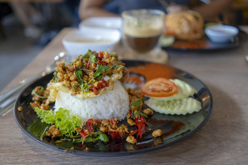 Rice topped with basil With fried eggs on the plate