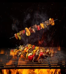 Foto auf Acrylglas Tasty skewers on the grill with flames © Lukas Gojda