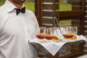 the waiter holds a tray with alcohol