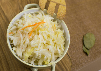 Sauerkraut in a bowl on a wooden background.