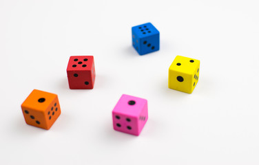Multicolored dice cubes on a light background.