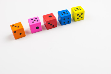 Multicolored dice cubes on a light background.