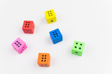 Multicolored dice cubes on a light background.