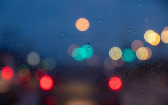 Blur image of car light at night while it's raining