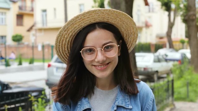 cute smiling brunette woman with elegant straw hat laughing on the street and looking at camera sunglasses fashion beauty industry joyful mood cheerful happy emotional female face having fun outside