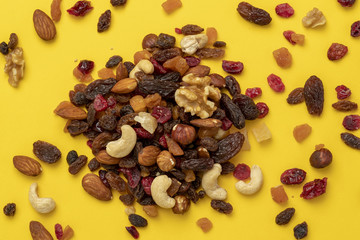 Mix of dried fruits and nuts on a yellow background