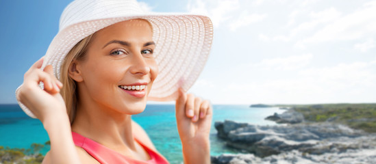 travel, summer holidays and tourism concept - portrait of beautiful smiling woman in sun hat over exotic beach background