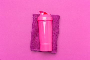 Pink plastic protein shaker cup on pink background