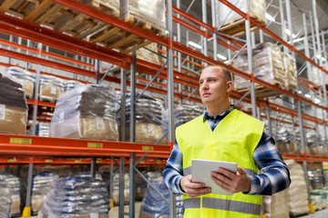 logistic business, technology, shipment and people concept - man or manual worker with tablet pc at...