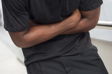 man suffering from stomachache; sick african man with stomachache, flatulence, gas in stomach, food...