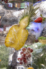 Obst, welches in einen Eisblock eingefroren ist