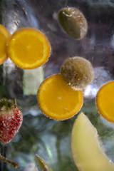 Obst, welches in einen Eisblock eingefroren ist