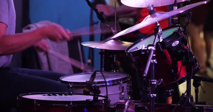 Close up side view of anonymous drummer performing at a bar