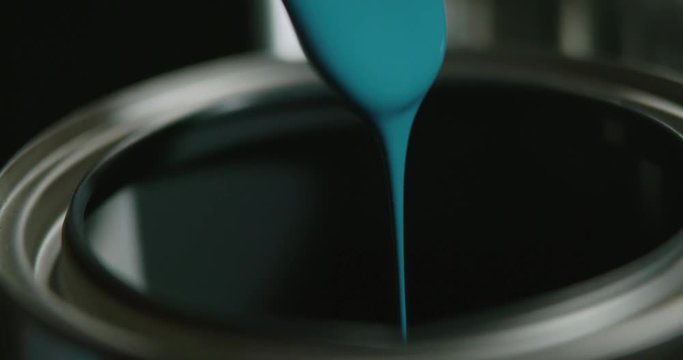 Pulling out paint from a paint can. Slow Motion.