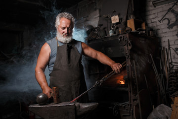 Blacksmith with brush handles the molten metal