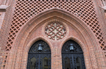 decorated entrance of an old church with red bricks