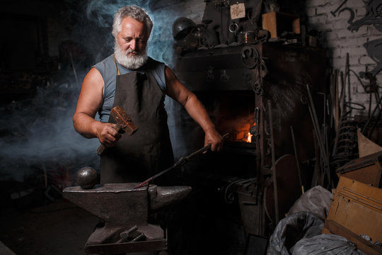 Blacksmith with brush handles the molten metal