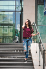 outdoor portrait of a stylish woman on the steps of shopping mall