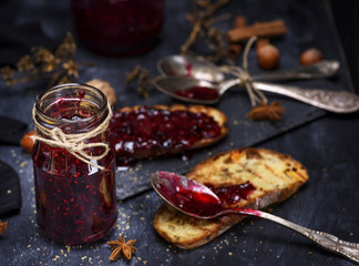  glass jar with raspberry jam and a slice of bread