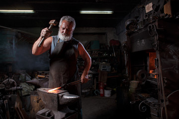 Fototapeta na wymiar Blacksmith with brush handles the molten metal