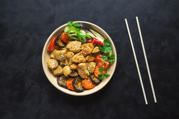 Pieces of baked meat with grilled vegetables on a plate. Chinese cuisine.