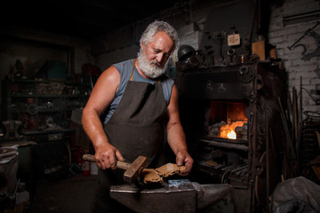 Blacksmith with brush handles the molten metal