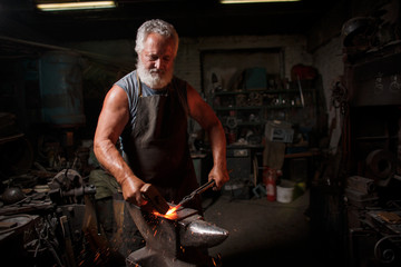 Blacksmith with brush handles the molten metal