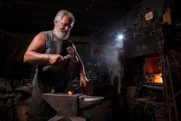 Blacksmith with brush handles the molten metal