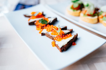 red caviar smeared with black bread on a platter