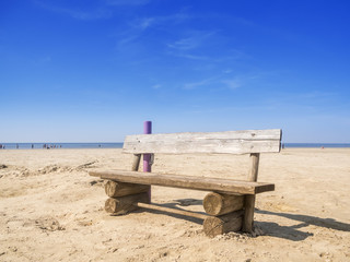 Fototapeta na wymiar Wooden bench on the beach