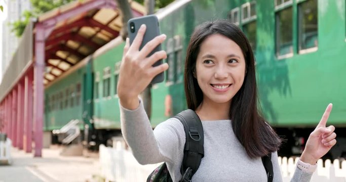 Woman taking selfie by mobile phone in the train station