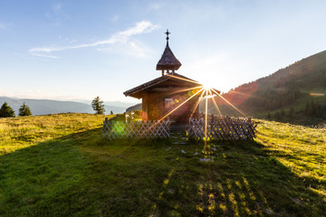 Kapelle am Berg mit Zaun beim Sonnenuntergang