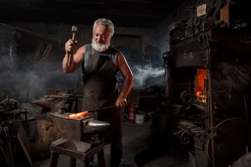 Blacksmith with brush handles the molten metal