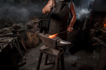 Blacksmith with brush handles the molten metal