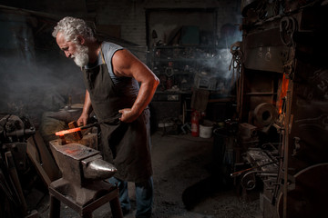 Blacksmith with brush handles the molten metal