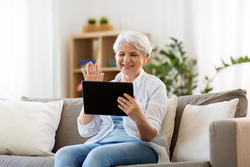 technology, people and communication concept - happy senior woman with tablet pc computer having...