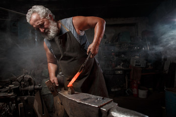 Blacksmith with brush handles the molten metal