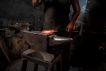 Blacksmith with brush handles the molten metal