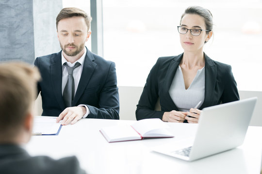 Portrait Of Two Successful Business People, Man And Woman,  Listening To Partner Sitting Across Meeting Table In Conference Room, Copy Space